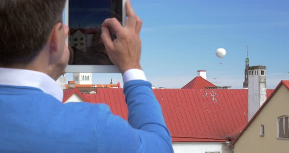 Man Shooting Air Balloon with Tablet