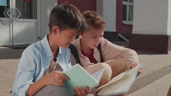 Boys Doing Homework on Steps of School Building