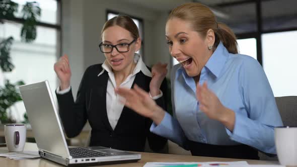 Two Female Entrepreneurs Excited With Great News on Laptop, Rejoicing Profits