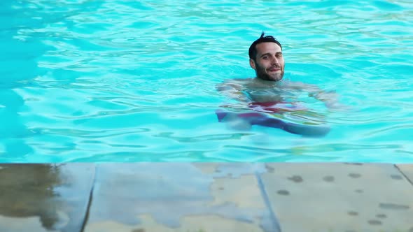 Smiling man swimming in the pool
