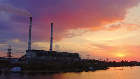 Manufacturing at sunset. Industrial factory near the river