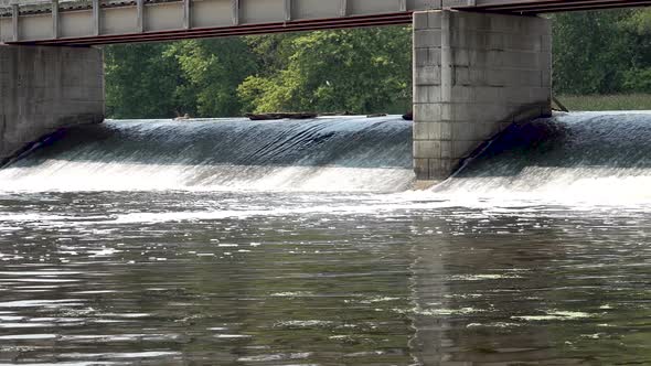 river water rushing under concrete bridge panning shot 4k