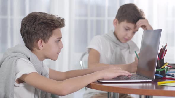 Side View Close-up of Caucasian Boy Playing Online Games on Laptop