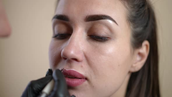 Closeup Face of Woman with Hand Contouring Lips with White in Slow Motion