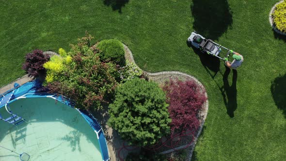 Man With Mowing Machine In Enormous Yard