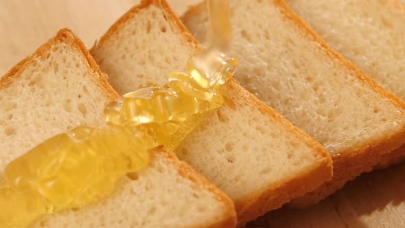 Toasted Bread with Flowing Down Honey on Wooden Bred, Slow Motion