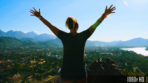 Back View of Excited Successful Woman Raising Arms While Enjoying View of Luang Prabang, Laos