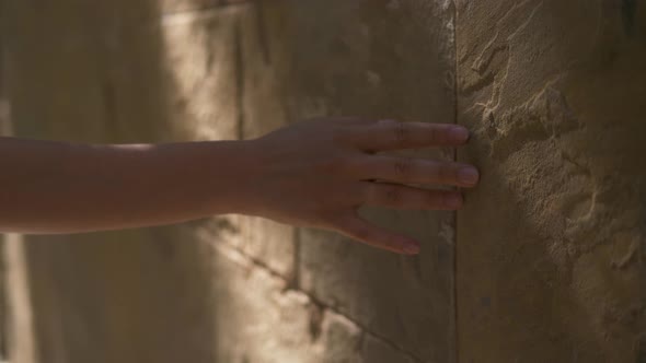 Close Up Women Hand Touches a White Concrete Wall with Sunshine, Shade and Shadow in the Morning