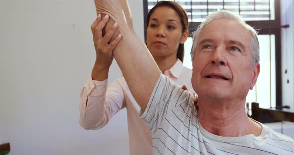 Physiotherapist assisting senior man with hand exercise 4k