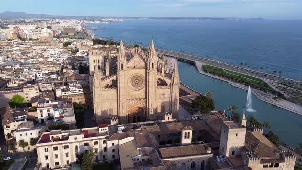 Aerial circling shot of front facade of Cathedral of St. Mary of Palma, Spain