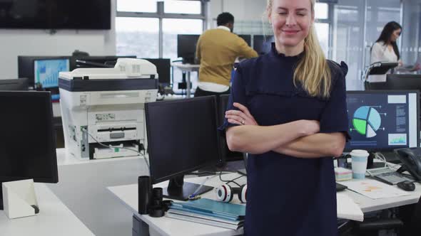 Woman crossing her arms and smiling while standing in office