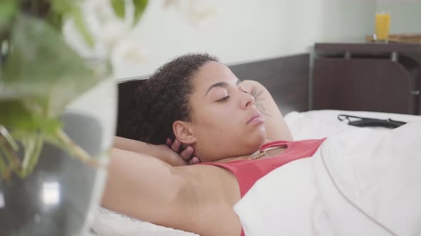 Cute African American Woman Lying in the Bed. Adorable Girl Relaxing at Home. Day Off of the Lady