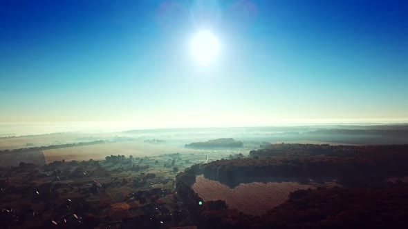 Morning sunrise in the village on misty weather. Panoramic view of beautiful dawn over the roofs