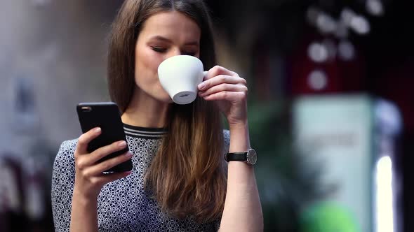 Woman With Mobile Phone Drinking Coffee In Cafe Portrait