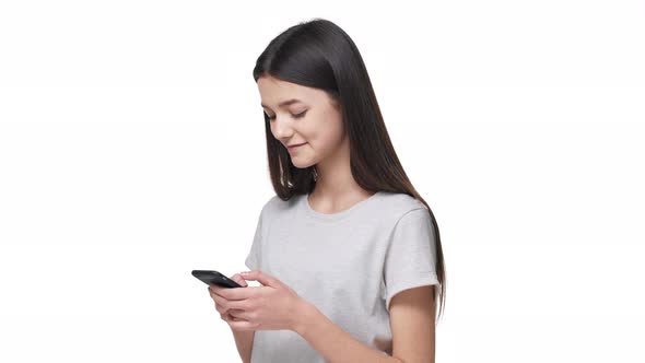 Portrait of Caucasian Woman Wearing Casual Clothes Smiling and Holding Smartphone While Browsing