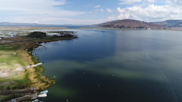 Slow drone movement in the city of Puno over Titicaca lake, Peru