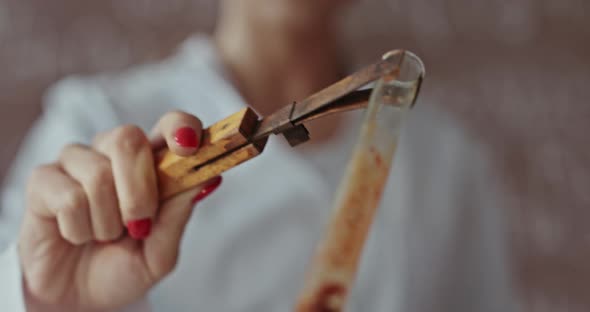 Young Female Scientist Wearing Glasses Heating a Chemical in a Test Tube Over an Open Flame alt