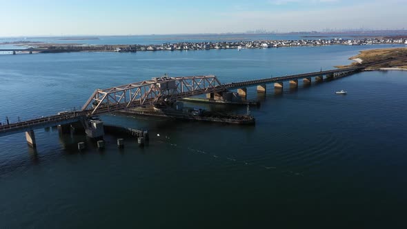 A high angle shot of an elevated train track which crosses a bay in Queens, NY. The camera truck lef