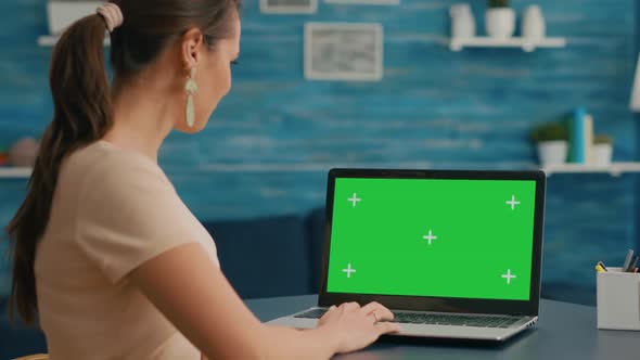 Business Woman Looking at Laptop Display with Mock Up Green Screen
