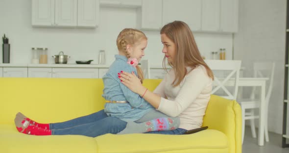 Caring Mother Consoling Her Upset Daughter on Sofa