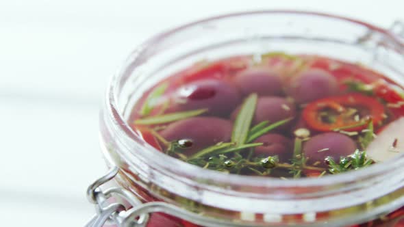 Pickled olives and herbs in a jar