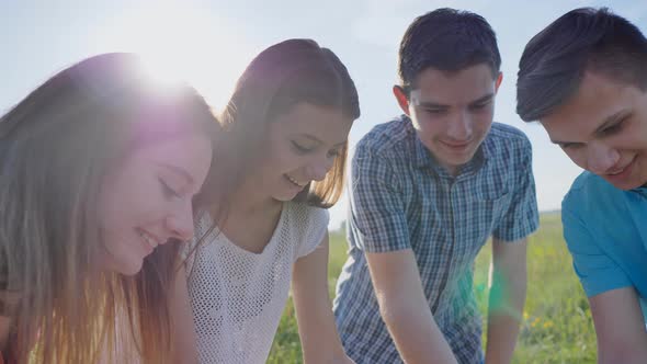 Friends of Schoolchildren Eat Pizza Outdoors During the Sunset in the Evening