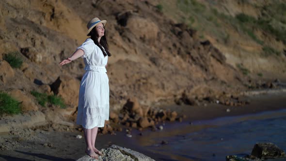 Woman Traveller with Arms Raised Looking at Sea