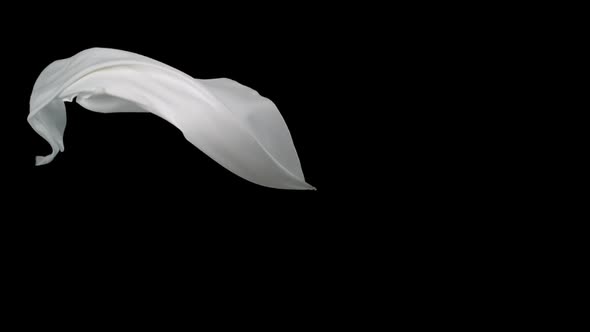 White fabric flowing on black background, Slow Motion alt