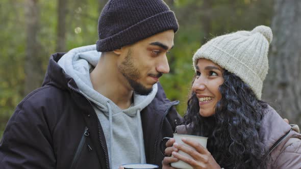 Young Happy Hispanic Couple in Love Closeup Standing Hugging Outdoors in Cold Weather Drinking Hot
