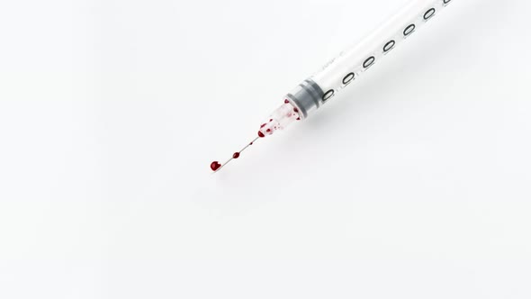 White Syringe with Blood Falls on the White Floor