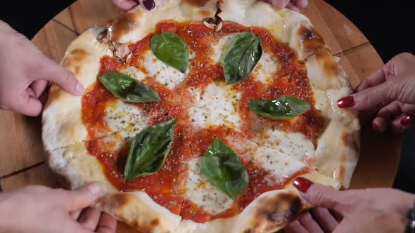 Top View Male and Female Hands Taking Slices of Pizza with Cheese, Tomato Sauce. Slow Motion Food