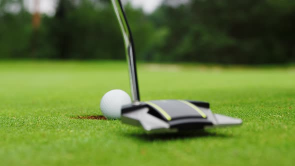 Young golfer playing with putter on course