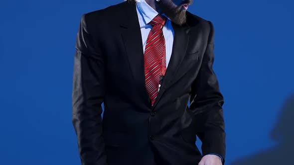 Elegant Man in a Black Hat Is Dancing an Erotic Dance. Spotlight on a Blue Background. Close Up