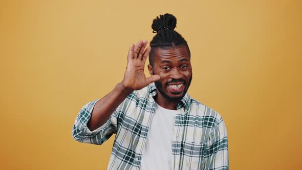 Young African American Male is Smiling Waving Hands Saying Hi Showing Thumbs Up Gesture