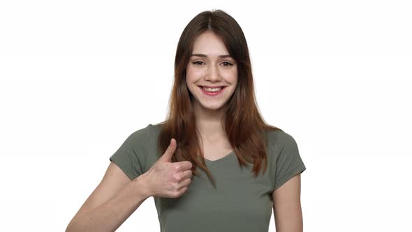Portrait of Woman in Basic Wear Being Happy with Results and Gesturing Thumb Up on Camera with