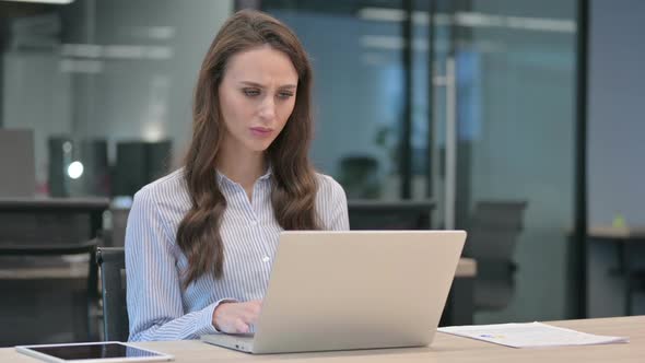 Young Businesswoman Reacting to Loss While using Laptop