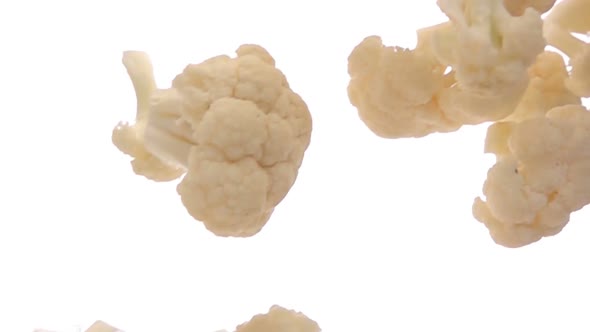 Closeup of the White Ripe Cauliflower Pieces Falling Diagonally in Slow Motion