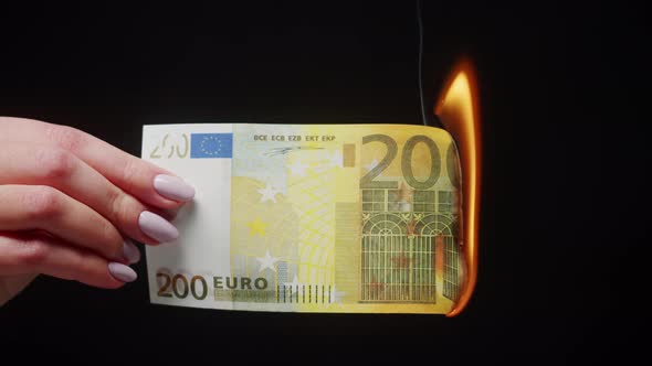 Burning of Two Hundred Euro Banknote on Black Background