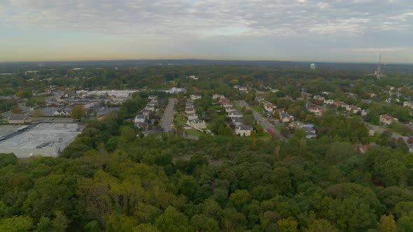 Backwards Aerial Pan of a Small Town Amongst Trees in Long Island