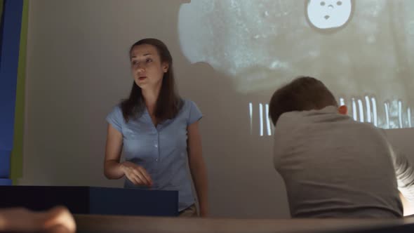 Woman Teaching Children How to Make Sand Animation