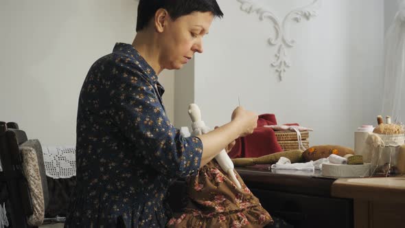 Seamstress sewing a doll