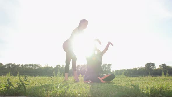 Fitness, Sport, Friendship and Lifestyle Concept - Two Young Women Are Training Stretching Outdoors