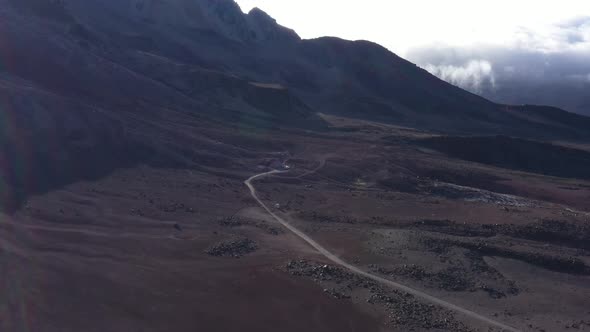 Aerial view flying over a dirt road on the slopes of the chimborazo vulcano to the first refugee