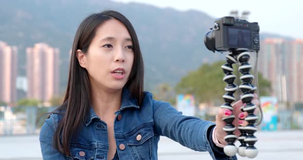 Woman taking video on digital camera for making vlog