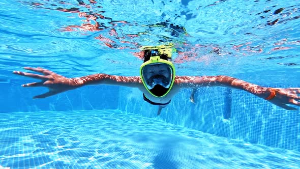 Boy in mask underwater in the swimming pool