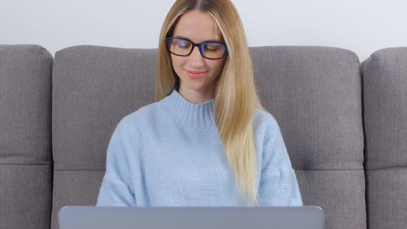 Cheerful entrepreneur woman working on notebook computer at home in 4k video