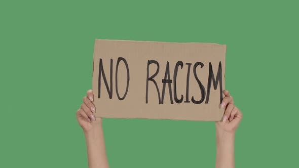 Sign NO RACISM Against the Background of a Green Screen, Chroma Key. Hands Hold Poster From a