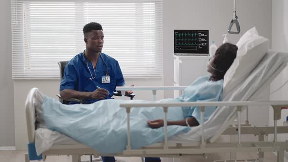 In the Hospital African American Beautiful Doctor Checking on Woman Patient Lying Down on Hospital