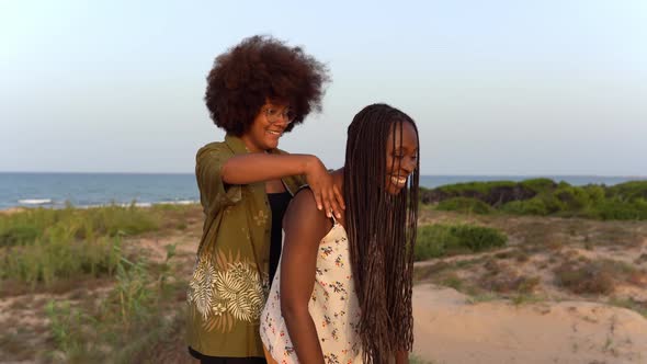 Black female friends having fun on beach