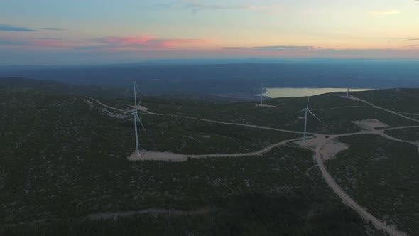 Aerial view of five windmills for the production of electric energy, at sunset